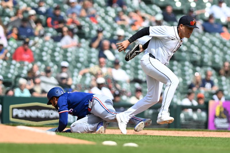 Apr 18, 2024; Detroit, Michigan, USA;  Texas Rangers center fielder Leody Taveras (3) ducks under the tag from Detroit Tigers third baseman Gio Urshela (13) while caught in a rundown between second and third base in the seventh inning at Comerica Park. Mandatory Credit: Lon Horwedel-USA TODAY Sports