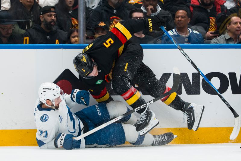 Mar 19, 2026; Vancouver, British Columbia, CAN; Vancouver Canucks defenseman Tom Willander (5) checks Tampa Bay Lightning forward Anthony Cirelli (71) in the first period at Rogers Arena. Mandatory Credit: Bob Frid-Imagn Images