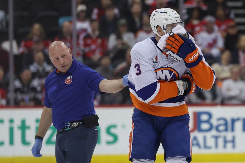 Apr 13, 2025; Newark, New Jersey, USA; New York Islanders defenseman Adam Pelech (3) leaves the ice after being hit by New Jersey Devils center Paul Cotter (47) (not pictured) during the second period at Prudential Center. Mandatory Credit: Ed Mulholland-Imagn Images
