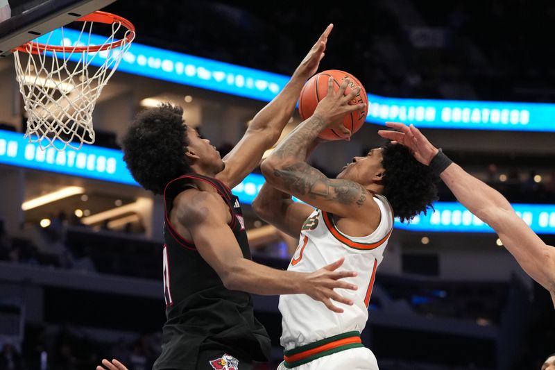 Mar 12, 2026; Charlotte, NC, USA; Miami (FL) Hurricanes guard Tru Washington (10) shoots as Louisville Cardinals guard Adrian Wooley (14) defends in the second half at Spectrum Center. Mandatory Credit: Bob Donnan-Imagn Images