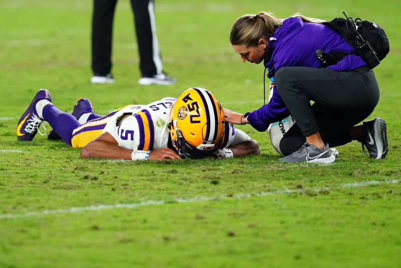 Nov 4, 2023; Tuscaloosa, Alabama, USA; LSU Tigers quarterback Jayden Daniels (5) lays on the ground after being hit by the Alabama Crimson Tide defense during the second half at Bryant-Denny Stadium. After review Alabama was penalized with roughing the passer. Mandatory Credit: John David Mercer-USA TODAY Sports