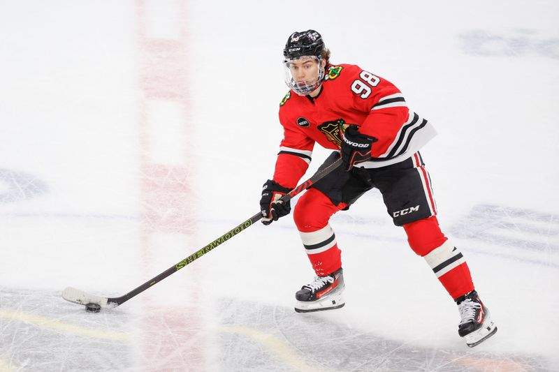 Mar 26, 2024; Chicago, Illinois, USA; Chicago Blackhawks center Connor Bedard (98) looks to pass the puck against the Calgary Flames during the first period at United Center. Mandatory Credit: Kamil Krzaczynski-USA TODAY Sports