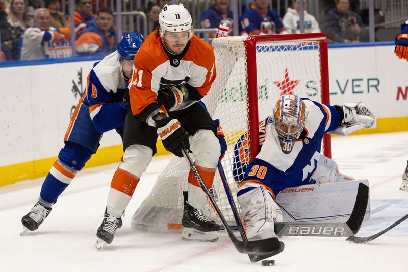 Nov 25, 2023; Elmont, New York, USA; Philadelphia Flyers right wing Travis Konecny (11) with the puck in front of New York Islanders goaltender Ilya Sorokin (30) during the first period at UBS Arena. Mandatory Credit: Thomas Salus-USA TODAY Sports