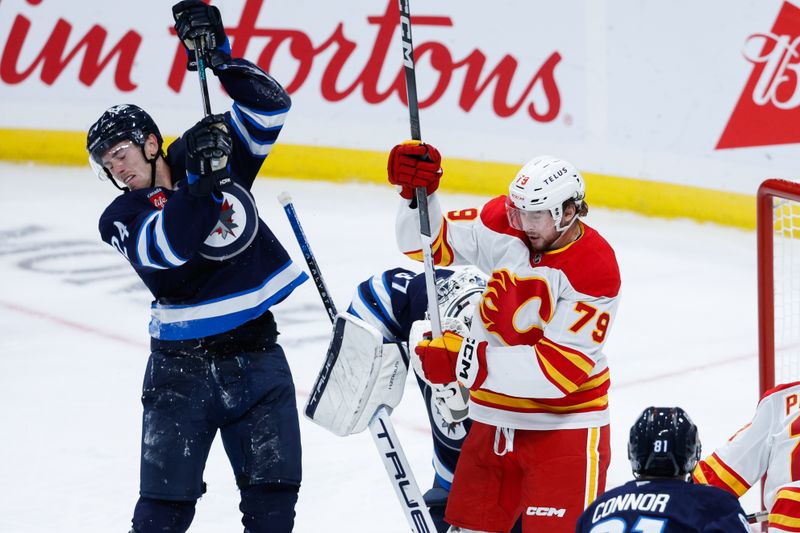 Oct 2, 2024; Winnipeg, Manitoba, CAN;  Calgary Flames forward Cole Schwindt (73) jostles for position with Winnipeg Jets defenseman Hayden Fleury (24) during the third period at Canada Life Centre. Mandatory Credit: Terrence Lee-Imagn Images