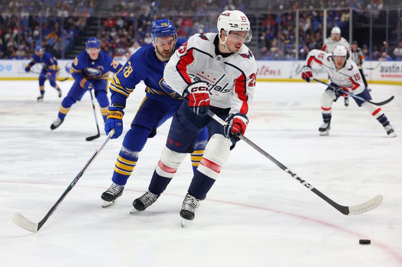 Apr 11, 2024; Buffalo, New York, USA;  Washington Capitals center Hendrix Lapierre (29) controls the puck as Buffalo Sabres left wing Zemgus Girgensons (28) defends during the first period at KeyBank Center. Mandatory Credit: Timothy T. Ludwig-USA TODAY Sports