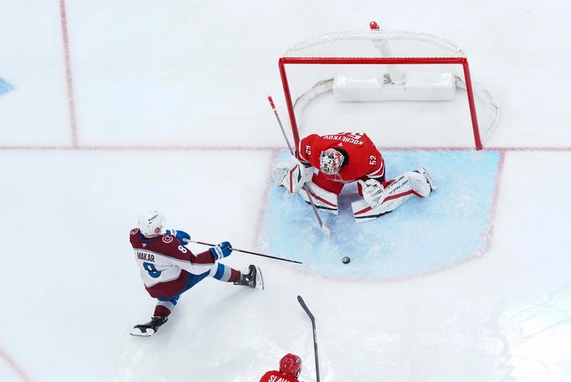 Dec 5, 2024; Raleigh, North Carolina, USA;  Carolina Hurricanes goaltender Pyotr Kochetkov (52) stops the shot by Colorado Avalanche defenseman Cale Makar (8) during the third period at Lenovo Center. Mandatory Credit: James Guillory-Imagn Images