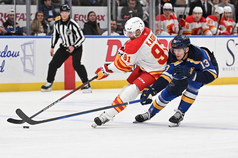 Jan 14, 2025; St. Louis, Missouri, USA; St. Louis Blues right wing Alexey Toropchenko (13) battles Calgary Flames center Nazem Kadri (91) for the puck in the first period at Enterprise Center. Mandatory Credit: Joe Puetz-Imagn Images