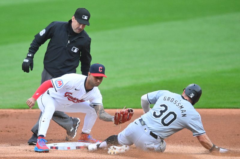 Apr 10, 2024; Cleveland, Ohio, USA; Chicago White Sox outfielder Robbie Grossman (30) steals second base beside Cleveland Guardians shortstop Brayan Rocchio (4) in the first inning at Progressive Field. Mandatory Credit: David Richard-USA TODAY Sports