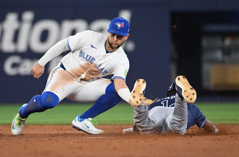 May 14, 2025; Toronto, Ontario, CAN;  Toronto Blue Jays shortstop Bo Bichette (11) tags out Tampa Bay Rays left fielder Chandler Simpson (14) who was trying to steal second base in the third inning at Rogers Centre. Mandatory Credit: Dan Hamilton-Imagn Images