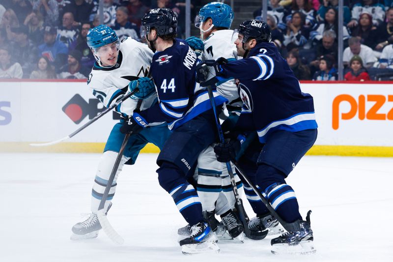 Feb 24, 2025; Winnipeg, Manitoba, CAN;  San Jose Sharks forward Collin Graf (51) and forward Nico Sturm (7) jostle for position with Winnipeg Jets defenseman Josh Morrissey (44) and defenseman Dylan DeMelo (2) during the first period at Canada Life Centre. Mandatory Credit: Terrence Lee-Imagn Images