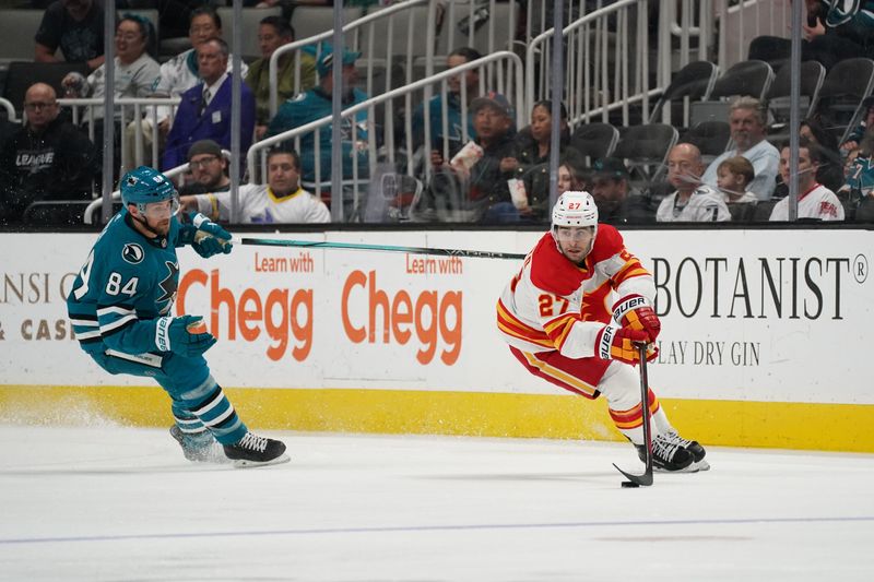 Apr 9, 2024; San Jose, California, USA; Calgary Flames right wing Matt Coronato (27) advances the puck against San Jose Sharks defenseman Jan Rutta (84) during the second period at SAP Center at San Jose. Mandatory Credit: David Gonzales-USA TODAY Sports