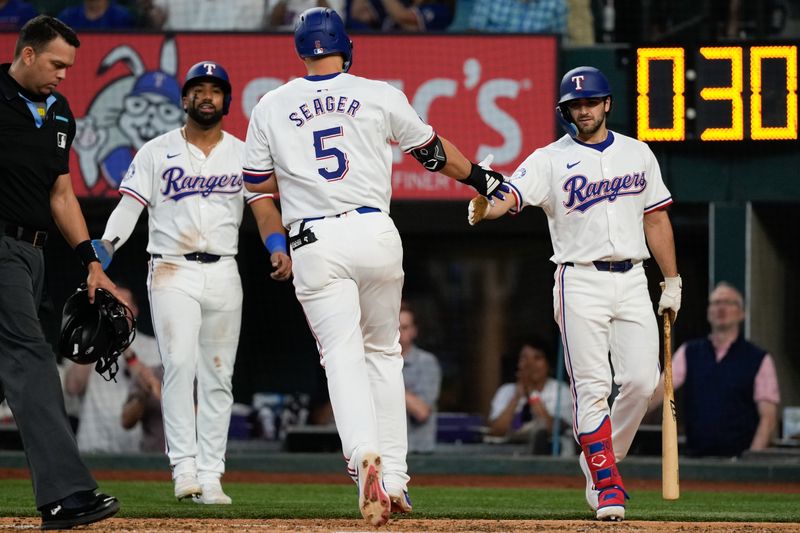 May 29, 2024; Arlington, Texas, USA;  Texas Rangers shortstop Corey Seager (5) celebrates his two-run home run with third baseman Josh Smith (right) and center fielder Leody Taveras (left) against the Arizona Diamondbacks during the fifth inning at Globe Life Field. Mandatory Credit: Jim Cowsert-USA TODAY Sports