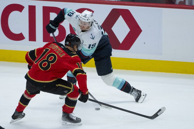 Oct 16, 2025; Ottawa, Ontario, CAN; Ottawa Senators center Tim Stutzle (18) battles for control of the puck with Seattle Kraken left wing Jared McCann (19) in the third period at the Canadian Tire Centre. Mandatory Credit: Marc DesRosiers-IMAGN Images