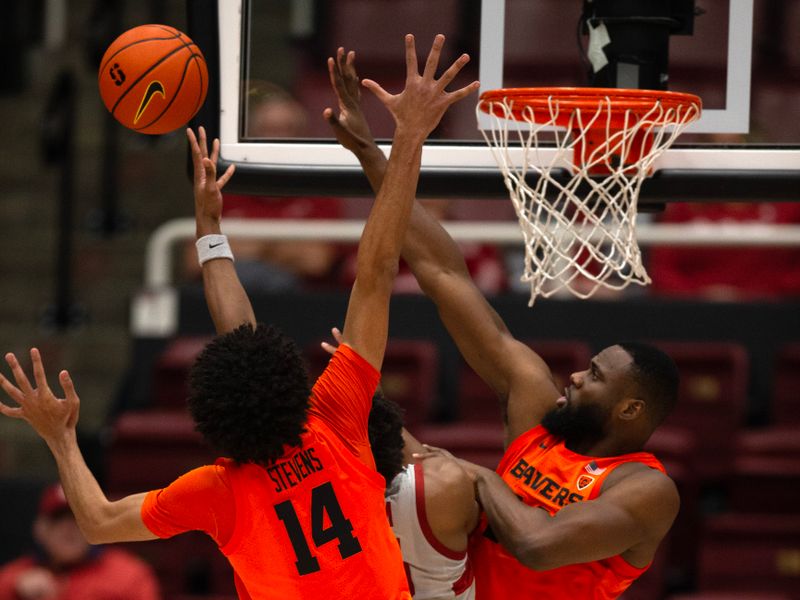 Jan 19, 2023; Stanford, California, USA; Oregon State Beavers forward Rodrigue Andela (right) rejects a shot by Stanford Cardinal forward Harrison Ingram (55) as Oregon State Beavers forward Jayden Stevens (14) helps with defense during the first half at Maples Pavilion. Mandatory Credit: D. Ross Cameron-USA TODAY Sports