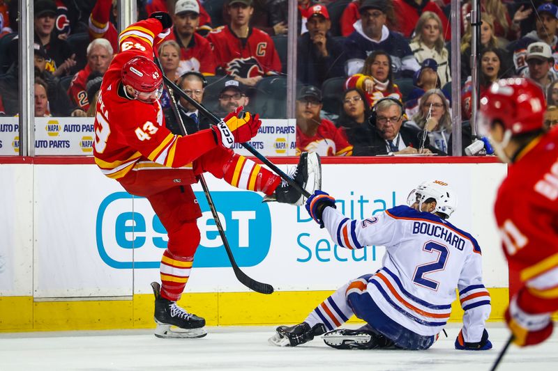 Dec 27, 2025; Calgary, Alberta, CAN; Edmonton Oilers defenseman Evan Bouchard (2) and Calgary Flames right wing Adam Klapka (43) battle for the puck during the first period at Scotiabank Saddledome. Mandatory Credit: Sergei Belski-Imagn Images