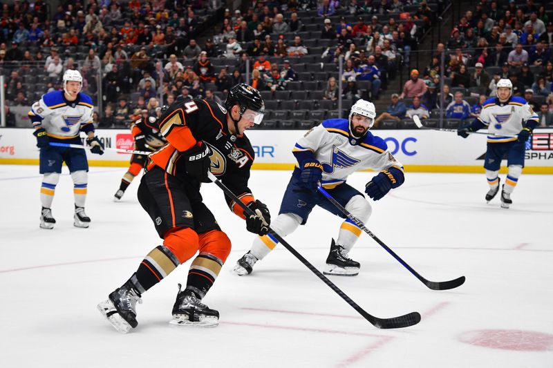 Apr 7, 2024; Anaheim, California, USA; Anaheim Ducks defenseman Cam Fowler (4) moves in for a shot against St. Louis Blues defenseman Nick Leddy (4) during the overtime period at Honda Center. Mandatory Credit: Gary A. Vasquez-USA TODAY Sports