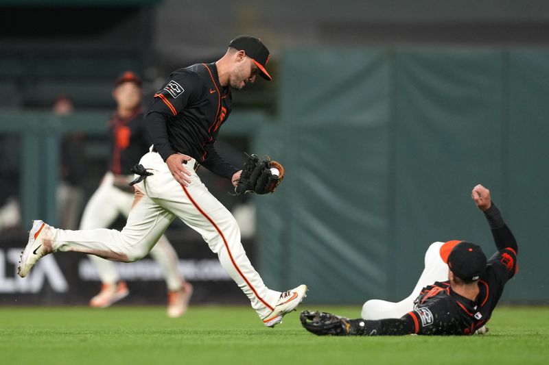 Apr 27, 2024; San Francisco, California, USA; San Francisco Giants left fielder Michael Conforto (left) catches a fly ball as shortstop Nick Ahmed (right) slides during the tenth inning against the Pittsburgh Pirates at Oracle Park. Mandatory Credit: Darren Yamashita-USA TODAY Sports