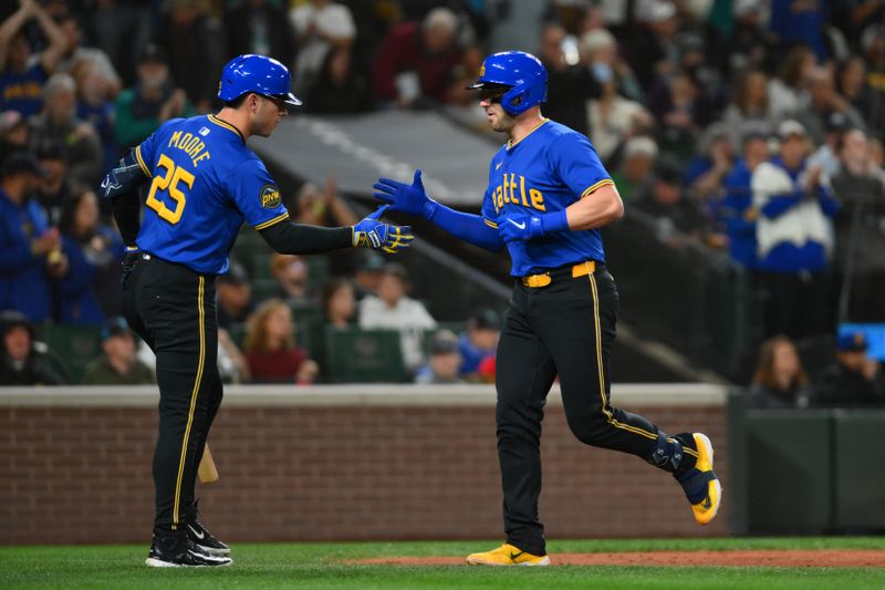 Sep 27, 2024; Seattle, Washington, USA; Seattle Mariners first baseman Dylan Moore (25) and catcher Mitch Garver (18) celebrate after Garver hit a home run against the Oakland Athletics during the second inning at T-Mobile Park. Mandatory Credit: Steven Bisig-Imagn Images