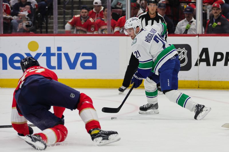 Oct 17, 2024; Sunrise, Florida, USA; Vancouver Canucks left wing Nils Hoglander (21) moves the puck against the Florida Panthers during the second period at Amerant Bank Arena. Mandatory Credit: Sam Navarro-Imagn Images