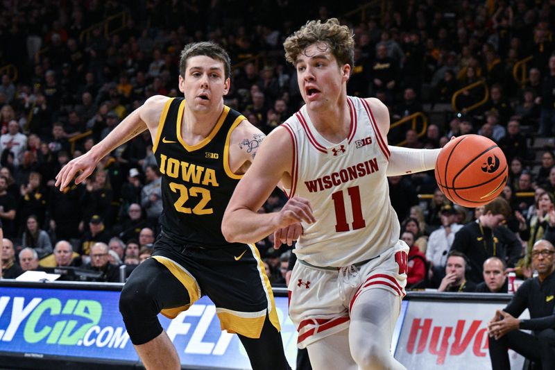 Feb 17, 2024; Iowa City, Iowa, USA; Wisconsin Badgers guard Max Klesmit (11) goes to the basket as Iowa Hawkeyes forward Patrick McCaffery (22) defends during the first half at Carver-Hawkeye Arena. Mandatory Credit: Jeffrey Becker-USA TODAY Sports