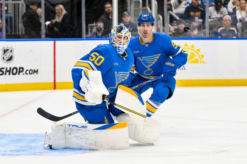 Nov 14, 2025; St. Louis, Missouri, USA; St. Louis Blues goaltender Jordan Binnington (50) and defenseman Matthew Kessel (51) defend the net against the Philadelphia Flyers during the third period at Enterprise Center. Mandatory Credit: Jeff Curry-Imagn Images