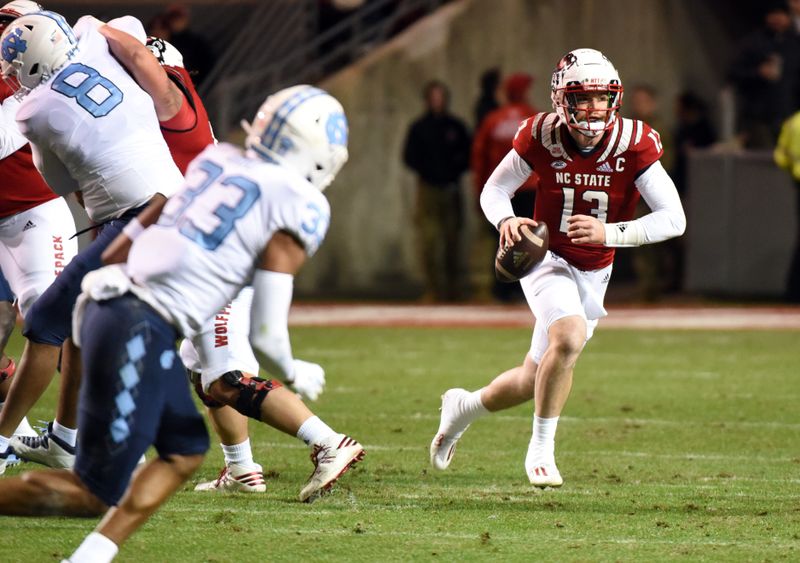 Nov 26, 2021; Raleigh, North Carolina, USA;  North Carolina State Wolfpack quarterback Devin Leary (13) looks to pass during the first half against the North Carolina Tar Heels at Carter-Finley Stadium. Mandatory Credit: Rob Kinnan-USA TODAY Sports