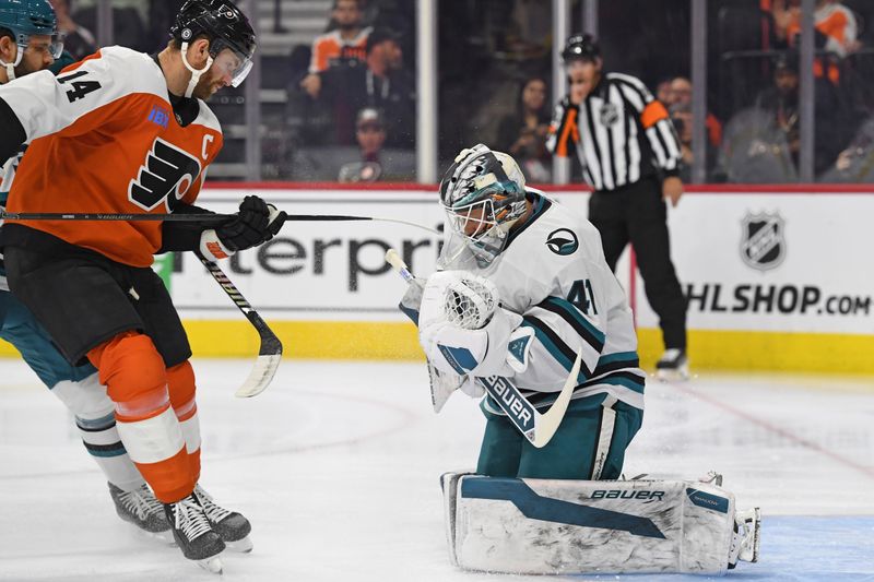 Nov 11, 2024; Philadelphia, Pennsylvania, USA; San Jose Sharks goaltender Vitek Vanecek (41) makes a save as Philadelphia Flyers center Sean Couturier (14) stands by during the first period at Wells Fargo Center. Mandatory Credit: Eric Hartline-Imagn Images