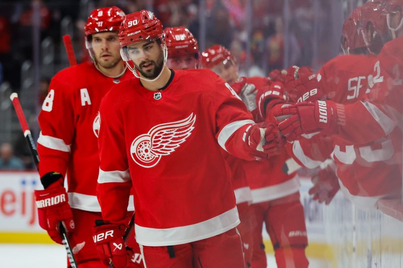 Oct 22, 2023; Detroit, Michigan, USA;  Detroit Red Wings center Joe Veleno (90) receives congratulations from teammates after scoring in the first period against the Calgary Flames at Little Caesars Arena. Mandatory Credit: Rick Osentoski-USA TODAY Sports