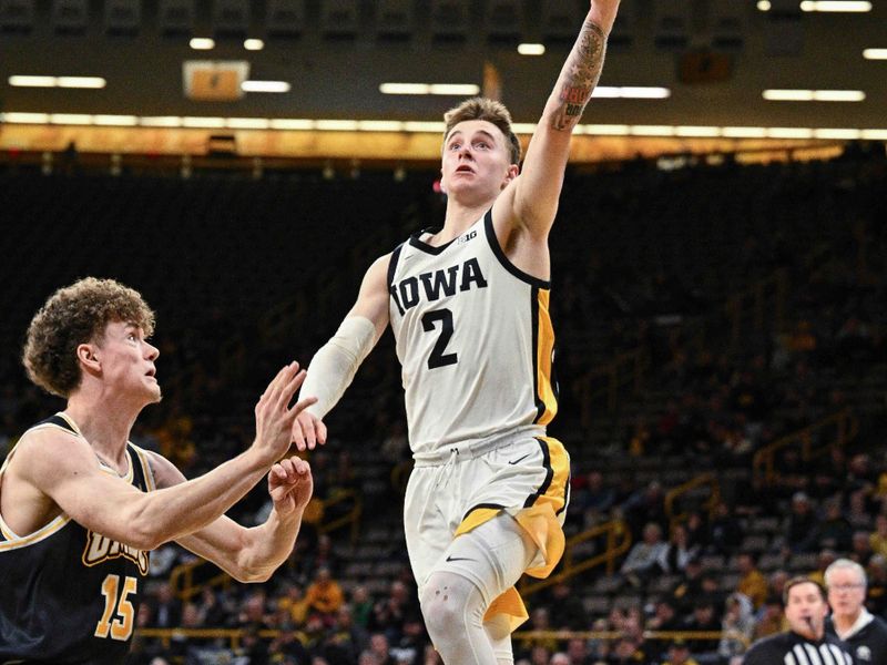 Dec 20, 2023; Iowa City, Iowa, USA; Iowa Hawkeyes guard Brock Harding (2) goes to the basket as UMBC Retrievers guard Ashton Reese (15) defends during the second half at Carver-Hawkeye Arena. Mandatory Credit: Jeffrey Becker-USA TODAY Sports