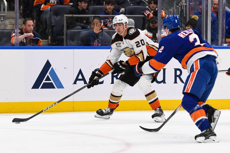 Dec 13, 2023; Elmont, New York, USA; Anaheim Ducks right wing Brett Leason (20) skates with the puck defedned by New York Islanders defenseman Mike Reilly (2) during the first period at UBS Arena. Mandatory Credit: Dennis Schneidler-USA TODAY Sports