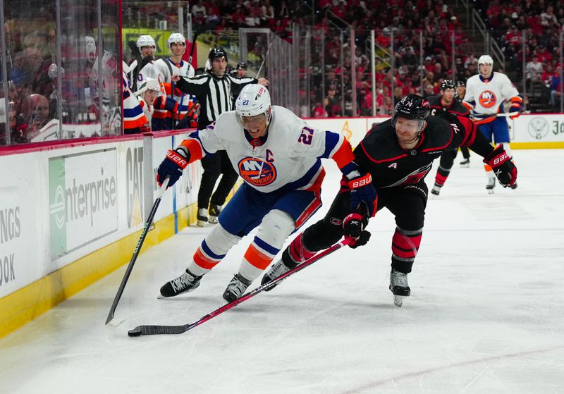 Apr 20, 2024; Raleigh, North Carolina, USA; New York Islanders center Kyle Palmieri (21) skates with the puck outside of Carolina Hurricanes defenseman Jaccob Slavin (74) during the second period in game one of the first round of the 2024 Stanley Cup Playoffs at PNC Arena. Mandatory Credit: James Guillory-USA TODAY Sports