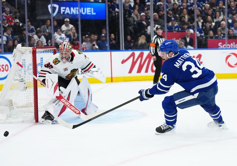 Dec 16, 2025; Toronto, Ontario, CAN; Toronto Maple Leafs center Auston Matthews (34) tries to play the puck in front of Chicago Blackhawks goaltender Spencer Knight (30) during the first period at Scotiabank Arena. Mandatory Credit: Nick Turchiaro-Imagn Images