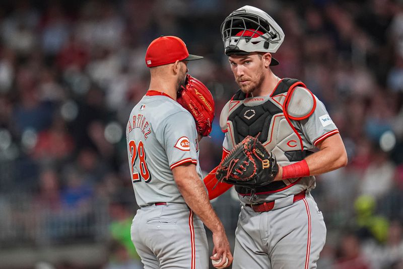 Sep 9, 2024; Cumberland, Georgia, USA; Cincinnati Reds catcher Tyler Stephenson (37) and starting pitcher Nick Martinez (28) talk on the mound during the game against the Atlanta Braves during the sixth inning at Truist Park. Mandatory Credit: Dale Zanine-Imagn Images