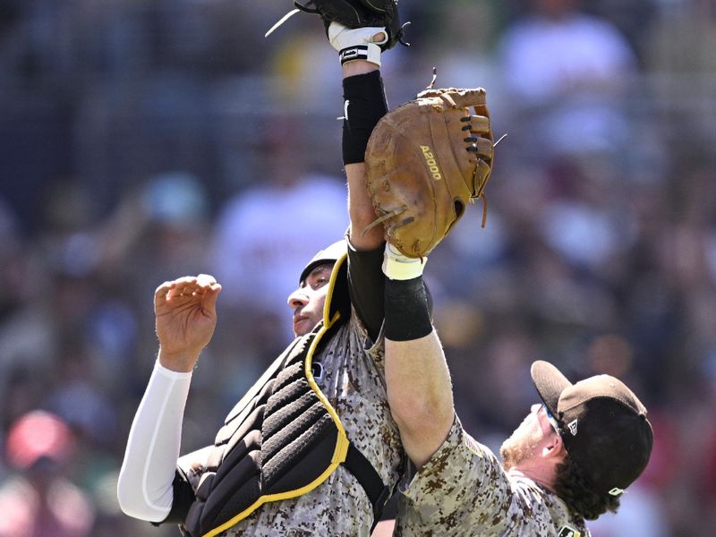 Apr 28, 2024; San Diego, California, USA; San Diego Padres catcher Kyle Higashioka (left) collides with first baseman Jake Cronenworth (9) after catching a pop-up during the seventh inning against the Philadelphia Phillies at Petco Park. Mandatory Credit: Orlando Ramirez-USA TODAY Sports