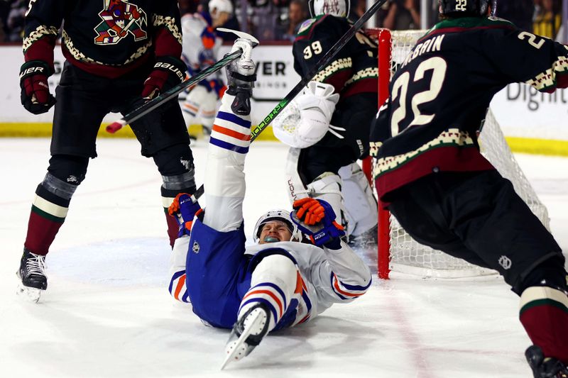 Apr 17, 2024; Tempe, Arizona, USA;  Edmonton Oilers left wing Warren Foegele (37) falls to the ice with a stick stuck in his stake during the first period of their game against the Arizona Coyotes at Mullett Arena. Mandatory Credit: Mark J. Rebilas-USA TODAY Sports