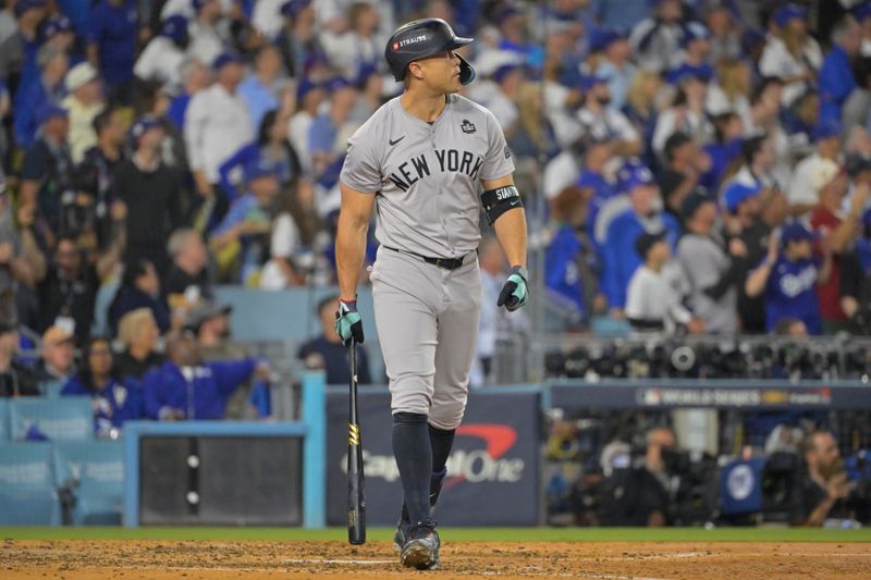 Oct 25, 2024; Los Angeles, California, USA; New York Yankees designated hitter Giancarlo Stanton (27) hits two-run home run in the sixth inning against the Los Angeles Dodgers during game one of the 2024 MLB World Series at Dodger Stadium. Mandatory Credit:  Jayne Kamin-Oncea-Imagn Images