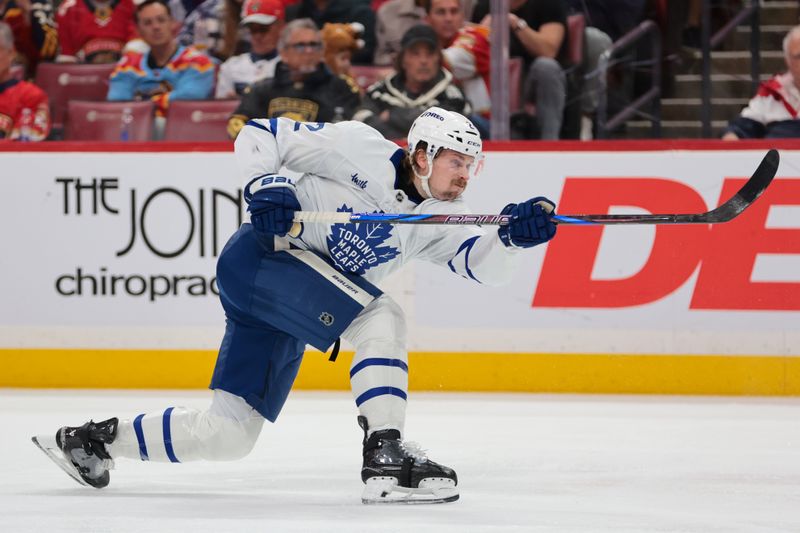 Dec 2, 2025; Sunrise, Florida, USA; Toronto Maple Leafs defenseman Simon Benoit (2) shoots the puck against the Florida Panthers during the second period at Amerant Bank Arena. Mandatory Credit: Sam Navarro-Imagn Images