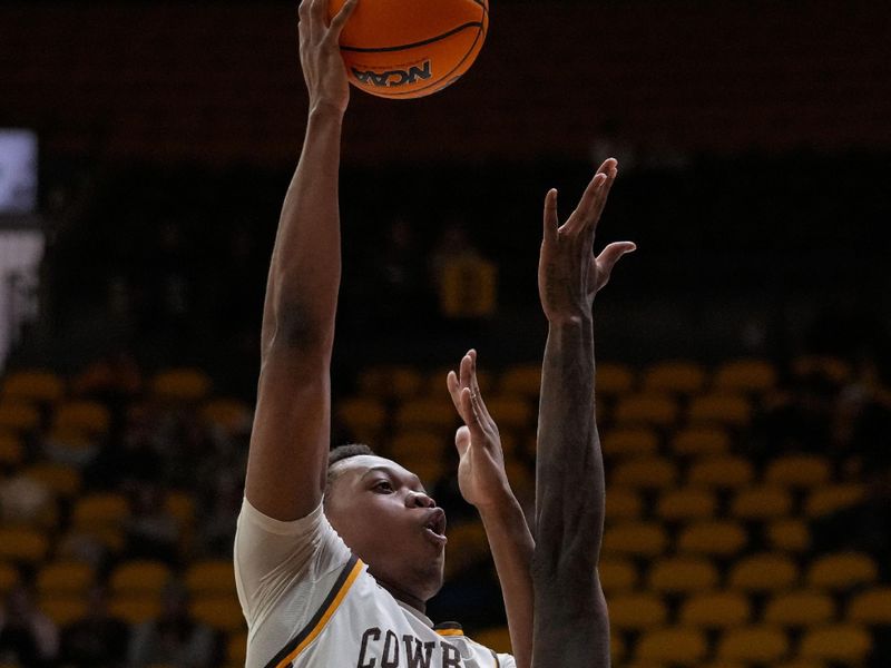 Feb 27, 2024; Laramie, Wyoming, USA; Wyoming Cowboys forward Cam Manyawu (5) shoots against UNLV Runnin' Rebels guard Kalib Boone (10) during overtime at Arena-Auditorium. Mandatory Credit: Troy Babbitt-USA TODAY Sports