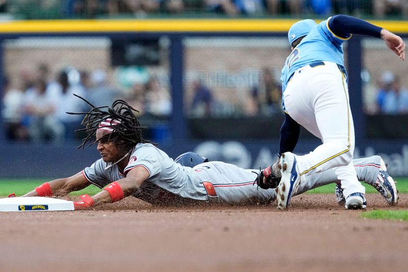 Jul 12, 2024; Milwaukee, Wisconsin, USA;  Washington Nationals shortstop CJ Abrams (5) steals second base before Milwaukee Brewers second baseman Brice Turang (2) can apply the tag during the first inning at American Family Field. Mandatory Credit: Jeff Hanisch-USA TODAY Sports