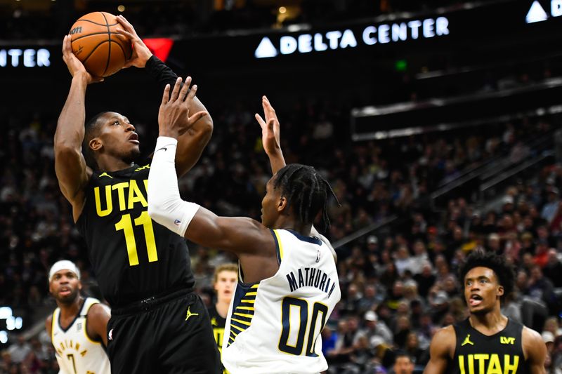 SALT LAKE CITY, UTAH - JANUARY 15: Kris Dunn #11 of the Utah Jazz shoots against Bennedict Mathurin #00 of the Indiana Pacers during the first half of a game at Delta Center on January 15, 2024 in Salt Lake City, Utah. NOTE TO USER: User expressly acknowledges and agrees that, by downloading and or using this photograph, User is consenting to the terms and conditions of the Getty Images License Agreement. (Photo by Alex Goodlett/Getty Images)