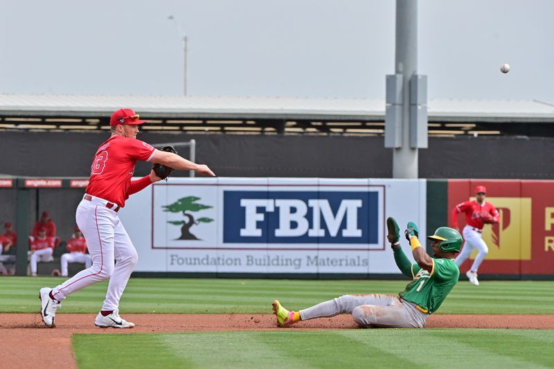 Mar 6, 2024; Tempe, Arizona, USA;  Los Angeles Angels second baseman Brandon Drury turns a double play on Oakland Athletics center fielder Esteury Ruiz (1) in the first inning during a spring training game at Tempe Diablo Stadium. Mandatory Credit: Matt Kartozian-USA TODAY Sports