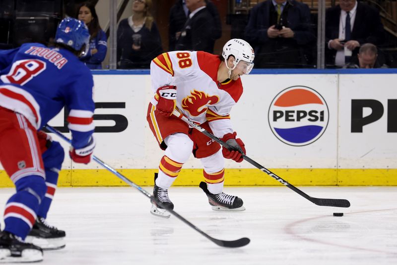 Feb 12, 2024; New York, New York, USA; Calgary Flames left wing Andrew Mangiapane (88) skates with the puck against New York Rangers defenseman Jacob Trouba (8) during the second period at Madison Square Garden. Mandatory Credit: Brad Penner-USA TODAY Sports