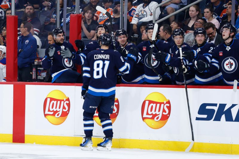 Sep 25, 2024; Winnipeg, Manitoba, CAN; Winnipeg Jets forward Kyle Connor (81) is congratulated by his teammates on his goal against the Edmonton Oilers during the second period at Canada Life Centre. Mandatory Credit: Terrence Lee-Imagn Images