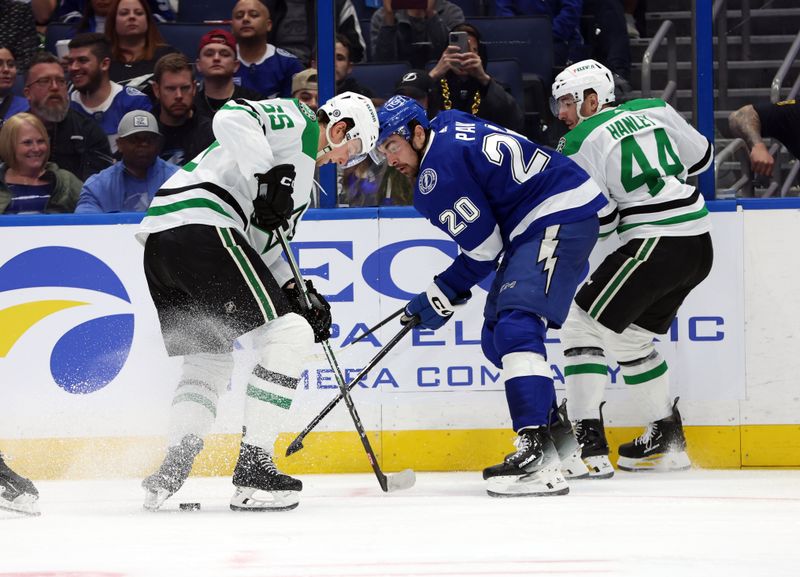 Dec 4, 2023; Tampa, Florida, USA; Dallas Stars defenseman Thomas Harley (55) and Tampa Bay Lightning left wing Nicholas Paul (20) fight to control the puck during the third period at Amalie Arena. Mandatory Credit: Kim Klement Neitzel-USA TODAY Sports