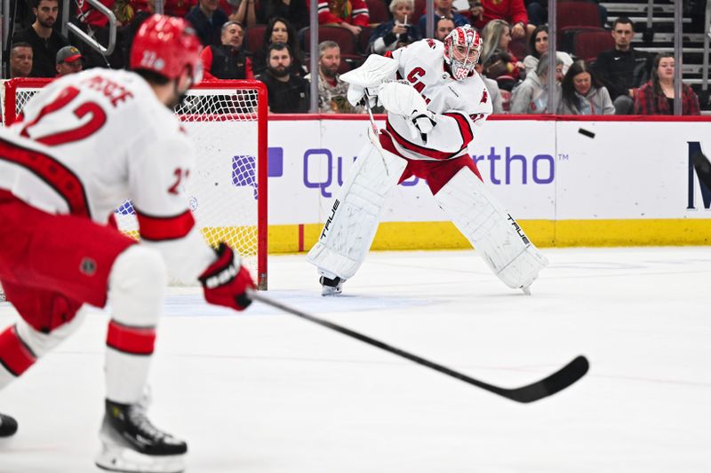 Apr 14, 2024; Chicago, Illinois, USA; Carolina Hurricanes goaltender Pyotr Kochetkov (52) clears the puck up the ice in the first period against the Chicago Blackhawks at United Center. Mandatory Credit: Jamie Sabau-USA TODAY Sports