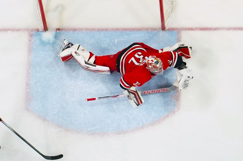 Jan 13, 2024; Raleigh, North Carolina, USA;  Carolina Hurricanes goaltender Antti Raanta (32) makes a glove save against the Pittsburgh Penguins during the third period at PNC Arena. Mandatory Credit: James Guillory-USA TODAY Sports