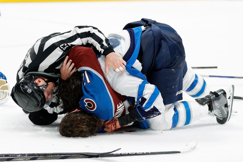 Apr 26, 2024; Denver, Colorado, USA; Linesman Matt MacPherson (83) attempts to separate Colorado Avalanche right wing Brandon Duhaime (12) and Winnipeg Jets defenseman Brenden Dillon (5) after game three of the first round of the 2024 Stanley Cup Playoffs at Ball Arena. Mandatory Credit: Isaiah J. Downing-USA TODAY Sports