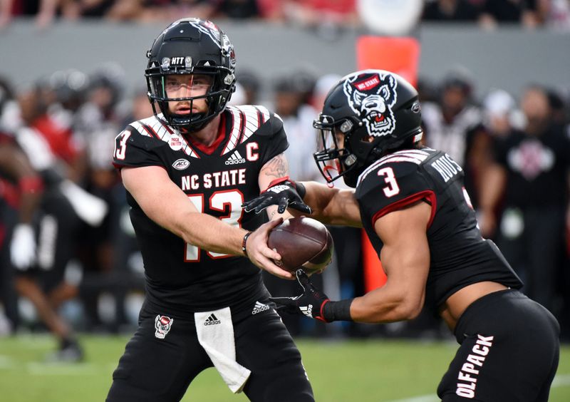 Sep 17, 2022; Raleigh, North Carolina, USA; North Carolina State Wolfpack quarterback Devin Leary (13) hands off to  running back Jordan Houston (3) during the first half against the Texas Tech Red Raiders at Carter-Finley Stadium. Mandatory Credit: Rob Kinnan-USA TODAY Sports