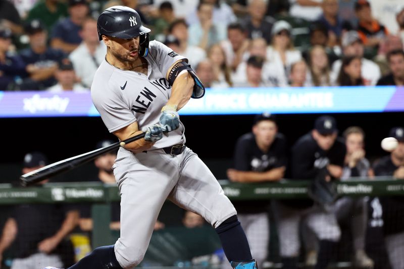 Sep 18, 2025; Baltimore, Maryland, USA; New York Yankees designated hitter Giancarlo Stanton (27) hits an RBI double during the seventh inning against the Baltimore Orioles at Oriole Park at Camden Yards. Mandatory Credit: Daniel Kucin Jr.-Imagn Images