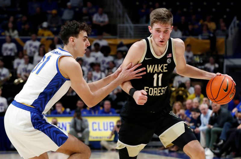 Jan 25, 2023; Pittsburgh, Pennsylvania, USA;  Wake Forest Demon Deacons forward Andrew Carr (11) dribbles against Pittsburgh Panthers forward Jorge Diaz Graham (31) during the first half at the Petersen Events Center. Mandatory Credit: Charles LeClaire-USA TODAY Sports